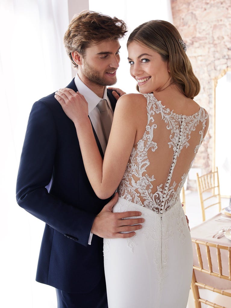 Ein Traum aus Spitze ist dieses umwerfende Kleid im Meerjungfrau-Stil mit zwei Lagen: Spitze über einem Unterkleid mit herzförmigem Dekolleté. Die zarten Flügelärmel bilden einen hübschen Kontrast zum sexy Keyhole-Rücken.