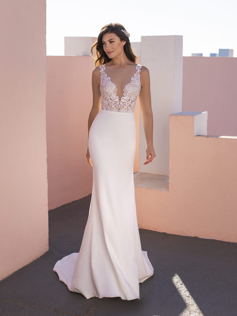 Ein Traum aus Spitze ist dieses umwerfende Kleid im Meerjungfrau-Stil mit zwei Lagen: Spitze über einem Unterkleid mit herzförmigem Dekolleté. Die zarten Flügelärmel bilden einen hübschen Kontrast zum sexy Keyhole-Rücken.