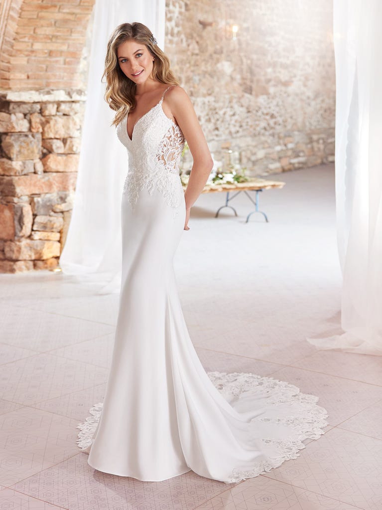 Ein Traum aus Spitze ist dieses umwerfende Kleid im Meerjungfrau-Stil mit zwei Lagen: Spitze über einem Unterkleid mit herzförmigem Dekolleté. Die zarten Flügelärmel bilden einen hübschen Kontrast zum sexy Keyhole-Rücken.