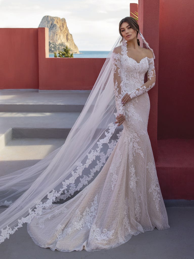 Ein Traum aus Spitze ist dieses umwerfende Kleid im Meerjungfrau-Stil mit zwei Lagen: Spitze über einem Unterkleid mit herzförmigem Dekolleté. Die zarten Flügelärmel bilden einen hübschen Kontrast zum sexy Keyhole-Rücken.