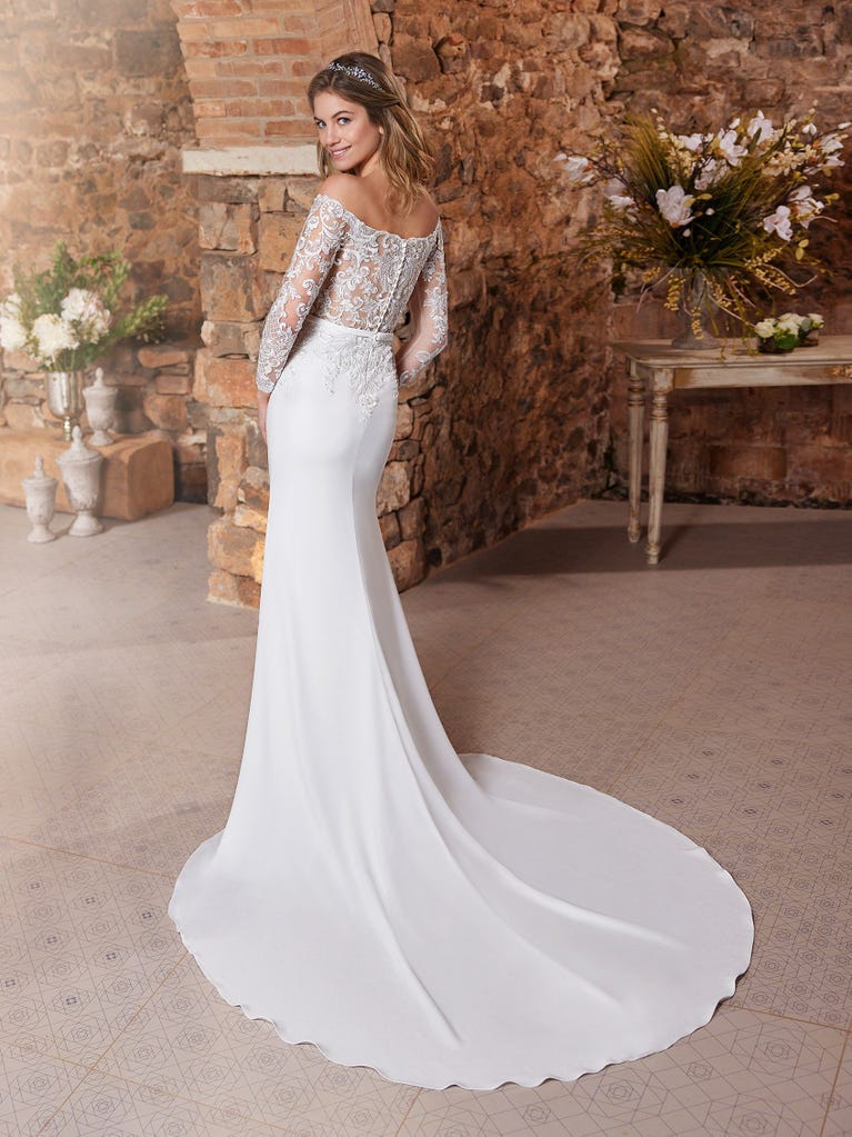 Ein Traum aus Spitze ist dieses umwerfende Kleid im Meerjungfrau-Stil mit zwei Lagen: Spitze über einem Unterkleid mit herzförmigem Dekolleté. Die zarten Flügelärmel bilden einen hübschen Kontrast zum sexy Keyhole-Rücken.