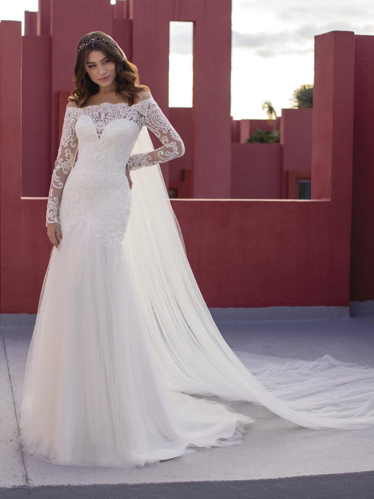 Ein Traum aus Spitze ist dieses umwerfende Kleid im Meerjungfrau-Stil mit zwei Lagen: Spitze über einem Unterkleid mit herzförmigem Dekolleté. Die zarten Flügelärmel bilden einen hübschen Kontrast zum sexy Keyhole-Rücken.