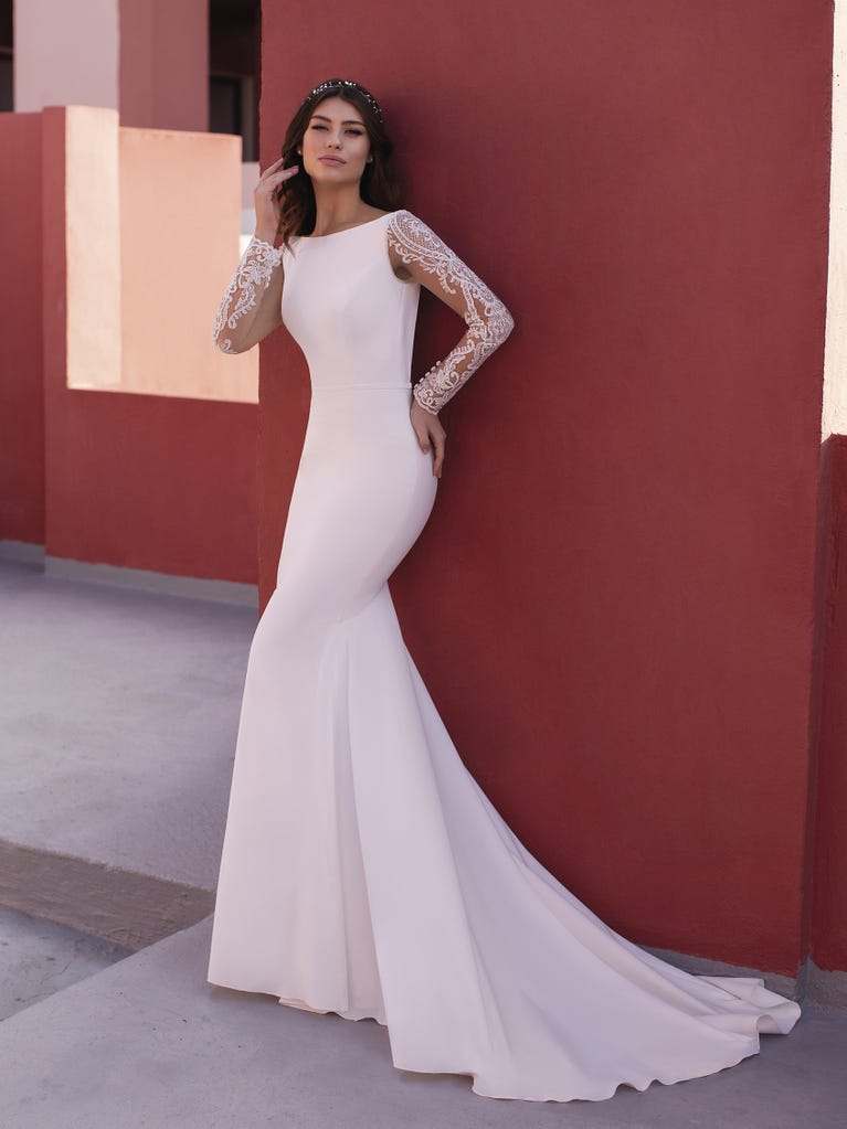 Ein Traum aus Spitze ist dieses umwerfende Kleid im Meerjungfrau-Stil mit zwei Lagen: Spitze über einem Unterkleid mit herzförmigem Dekolleté. Die zarten Flügelärmel bilden einen hübschen Kontrast zum sexy Keyhole-Rücken.