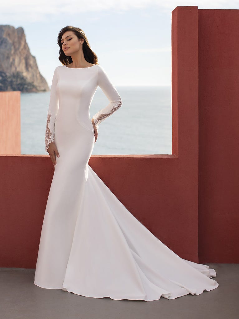 Ein Traum aus Spitze ist dieses umwerfende Kleid im Meerjungfrau-Stil mit zwei Lagen: Spitze über einem Unterkleid mit herzförmigem Dekolleté. Die zarten Flügelärmel bilden einen hübschen Kontrast zum sexy Keyhole-Rücken.