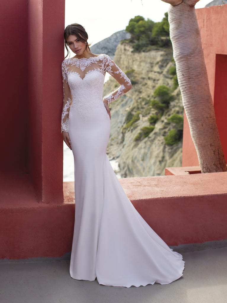 Ein Traum aus Spitze ist dieses umwerfende Kleid im Meerjungfrau-Stil mit zwei Lagen: Spitze über einem Unterkleid mit herzförmigem Dekolleté. Die zarten Flügelärmel bilden einen hübschen Kontrast zum sexy Keyhole-Rücken.